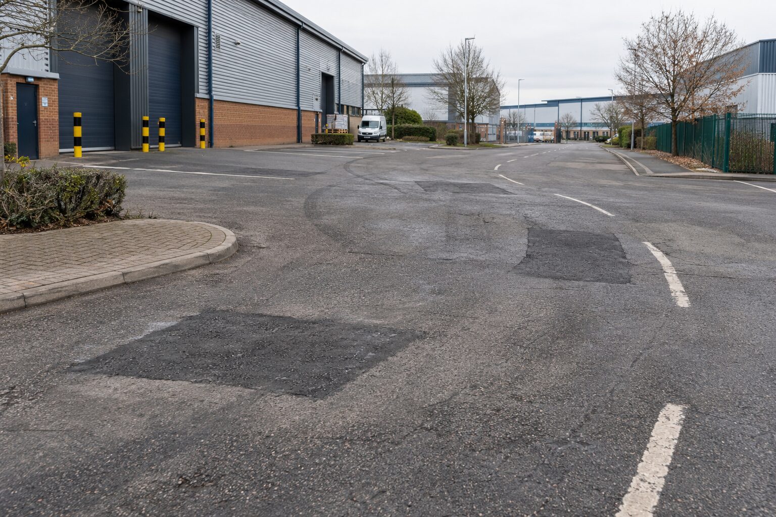 Completed asphalt patches along a commercial access route