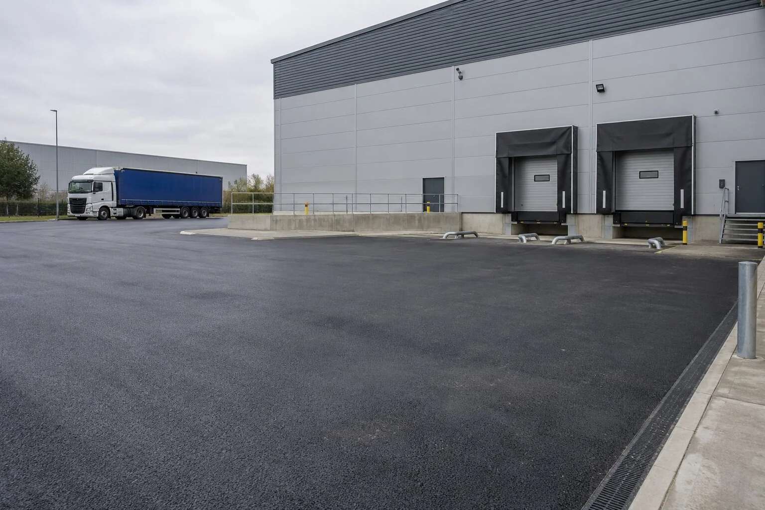 Completed tarmac service yard beside a distribution warehouse